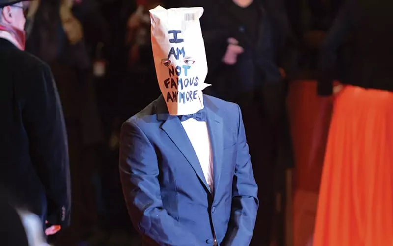 Shia LaBeouf walks red carpet with bag over head